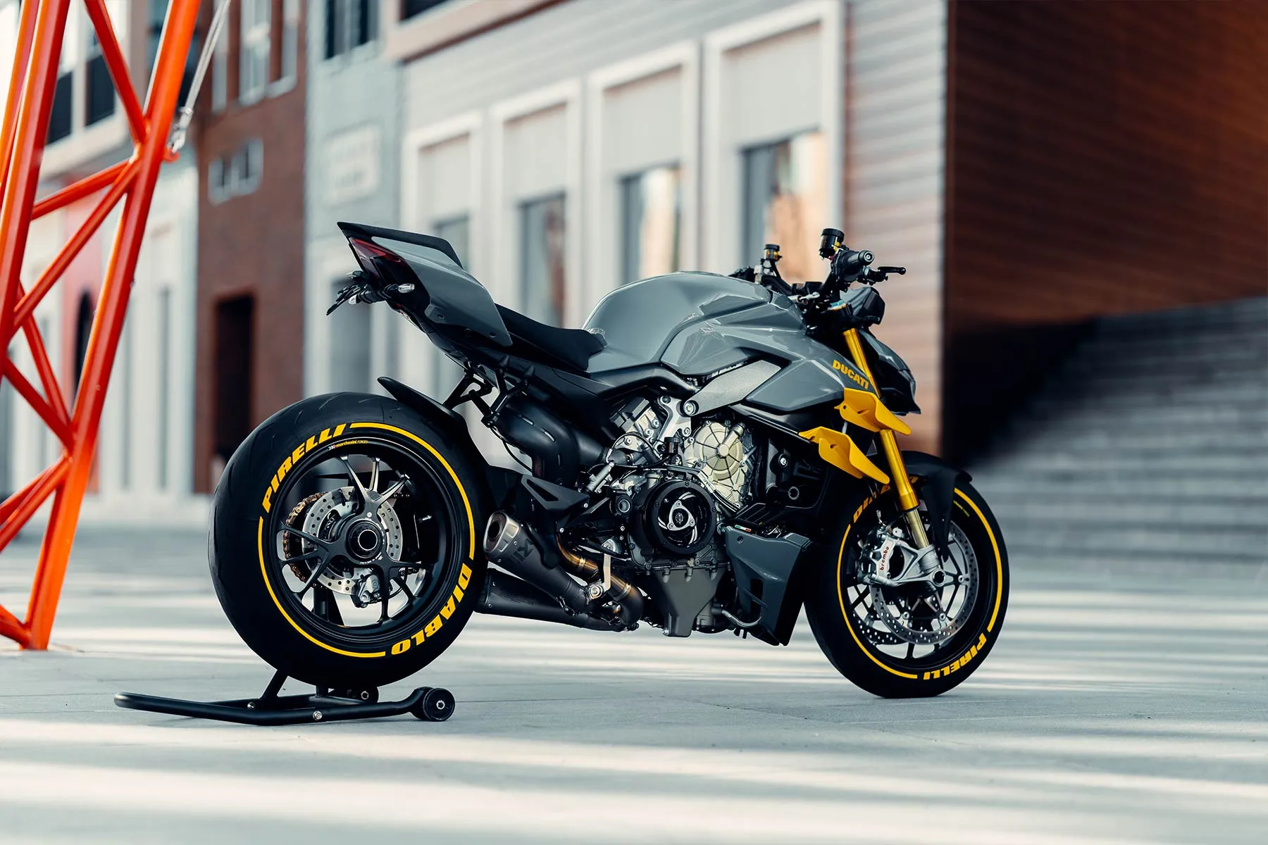 Hall-kollane Ducati Streetfighter V4 tellismaja ees, kollased velgede triibud