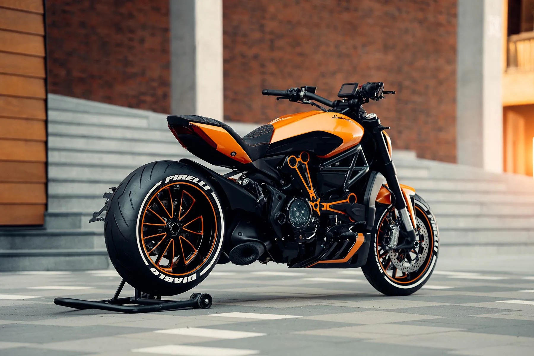 Oranž-must Ducati XDiavel küljelt betoontrepi ees